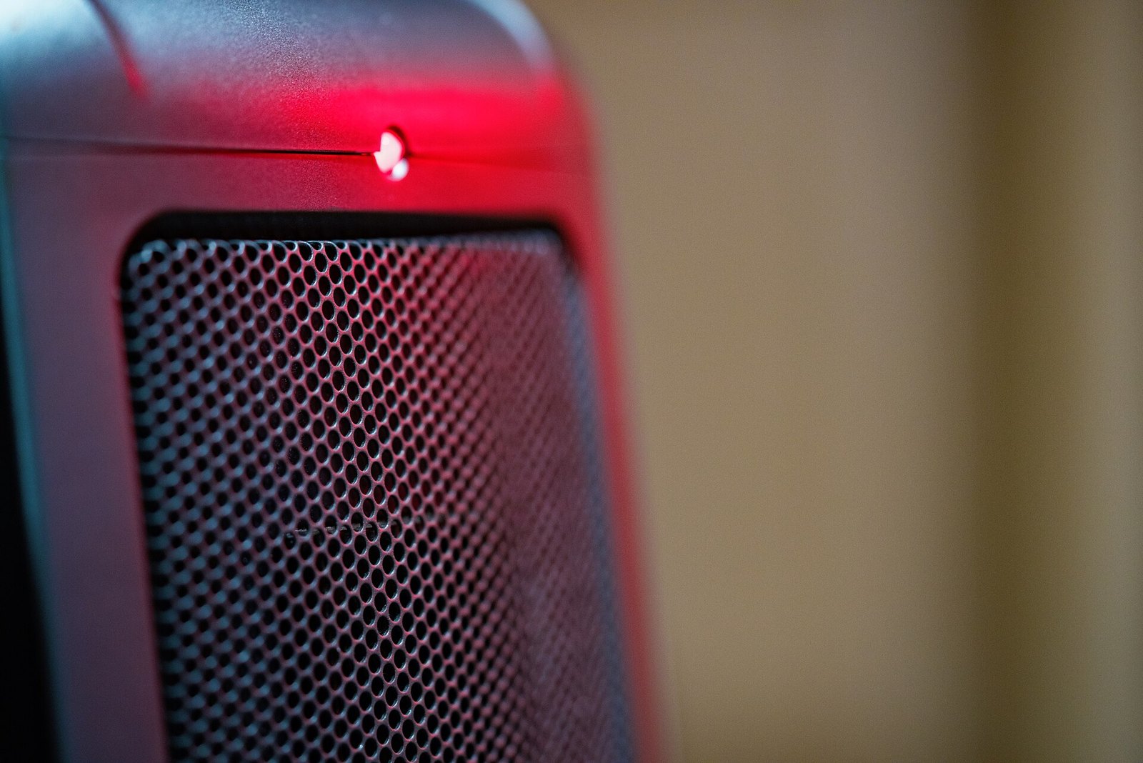 Close view of the grille of an electric ceramic space heater with a glowing red power light