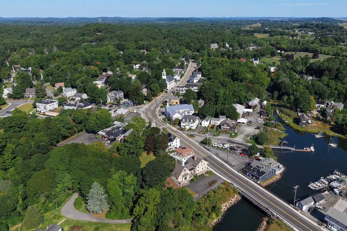 Aerial view of downtown Essex, with Main Street crossing the Essex River bridge and boats moored along the river